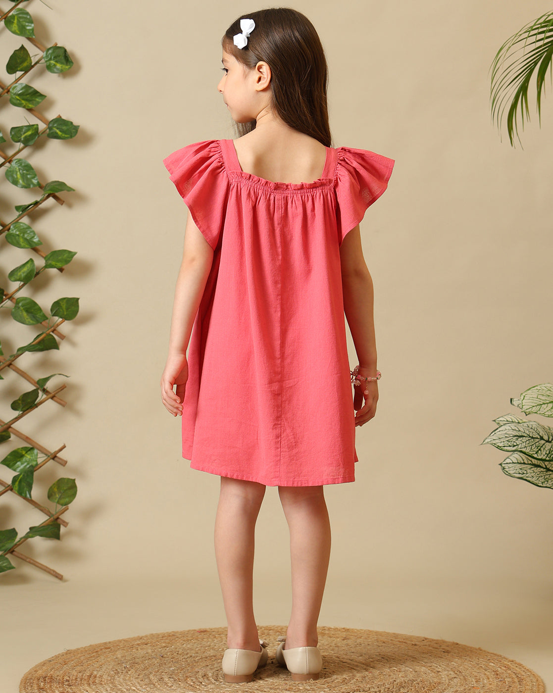 Coral pink girls embroidered dress with ruffle sleeves, gathered neckline and floral hem detailing