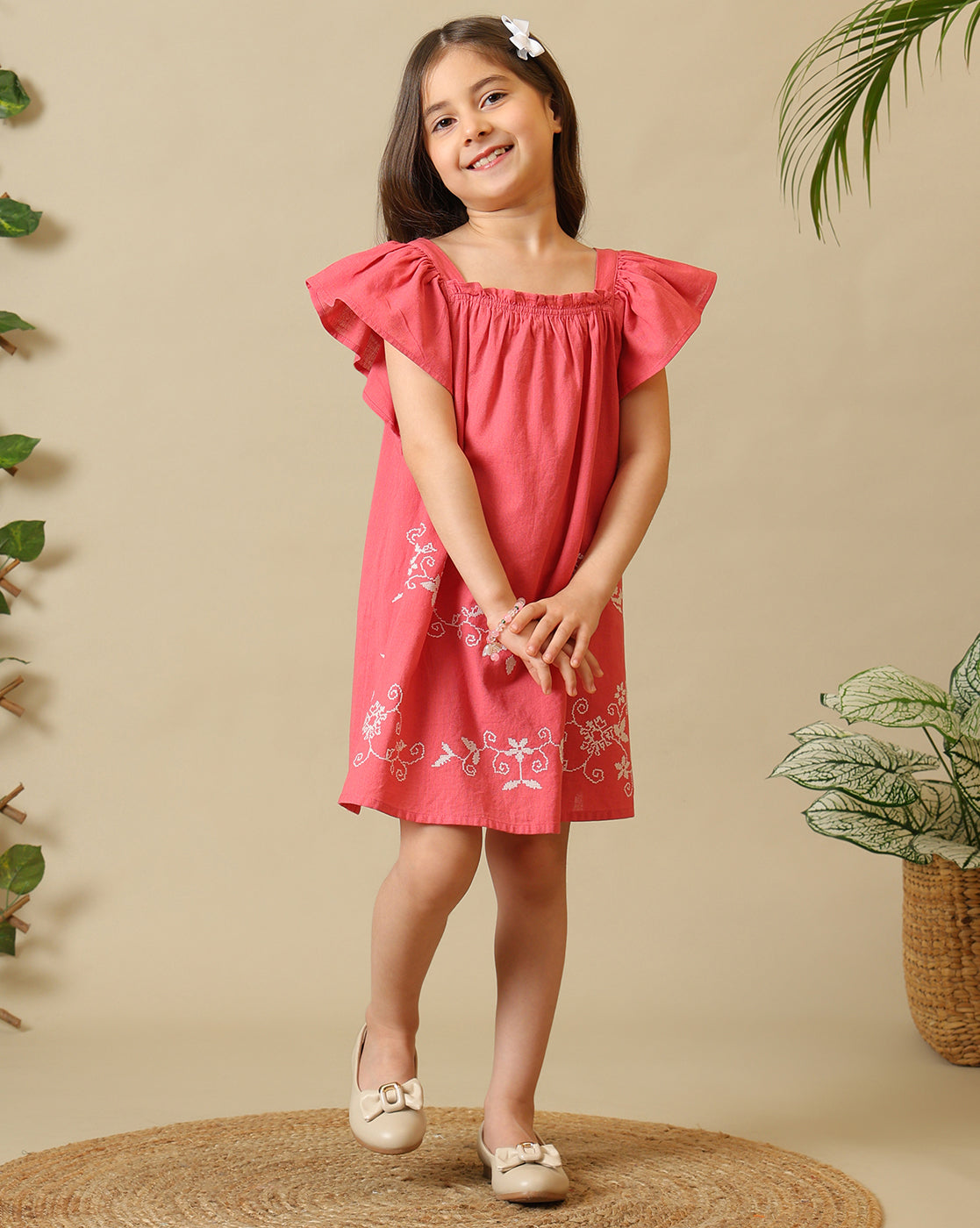 Coral pink girls embroidered dress with ruffle sleeves, gathered neckline and floral hem detailing