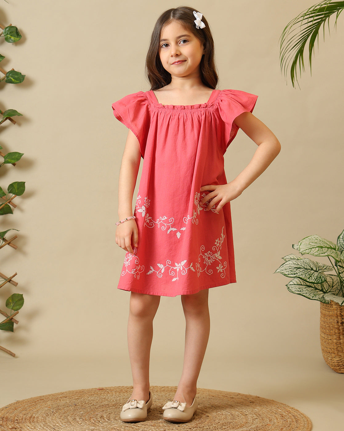 Coral pink girls embroidered dress with ruffle sleeves, gathered neckline and floral hem detailing