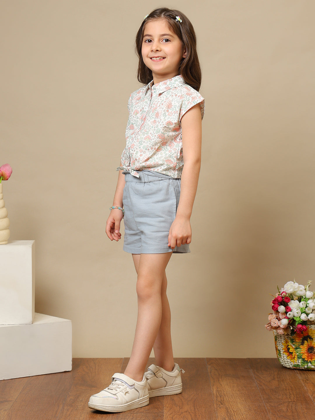 White girls floral printed sleeveless top with ruffle detailing and blue shorts