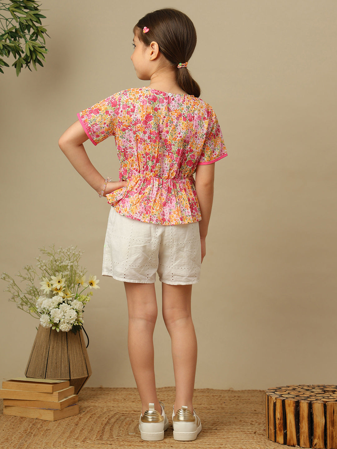 Girls floral print cotton top with bow detailing, short sleeves, pintucks and gathered peplum hem.