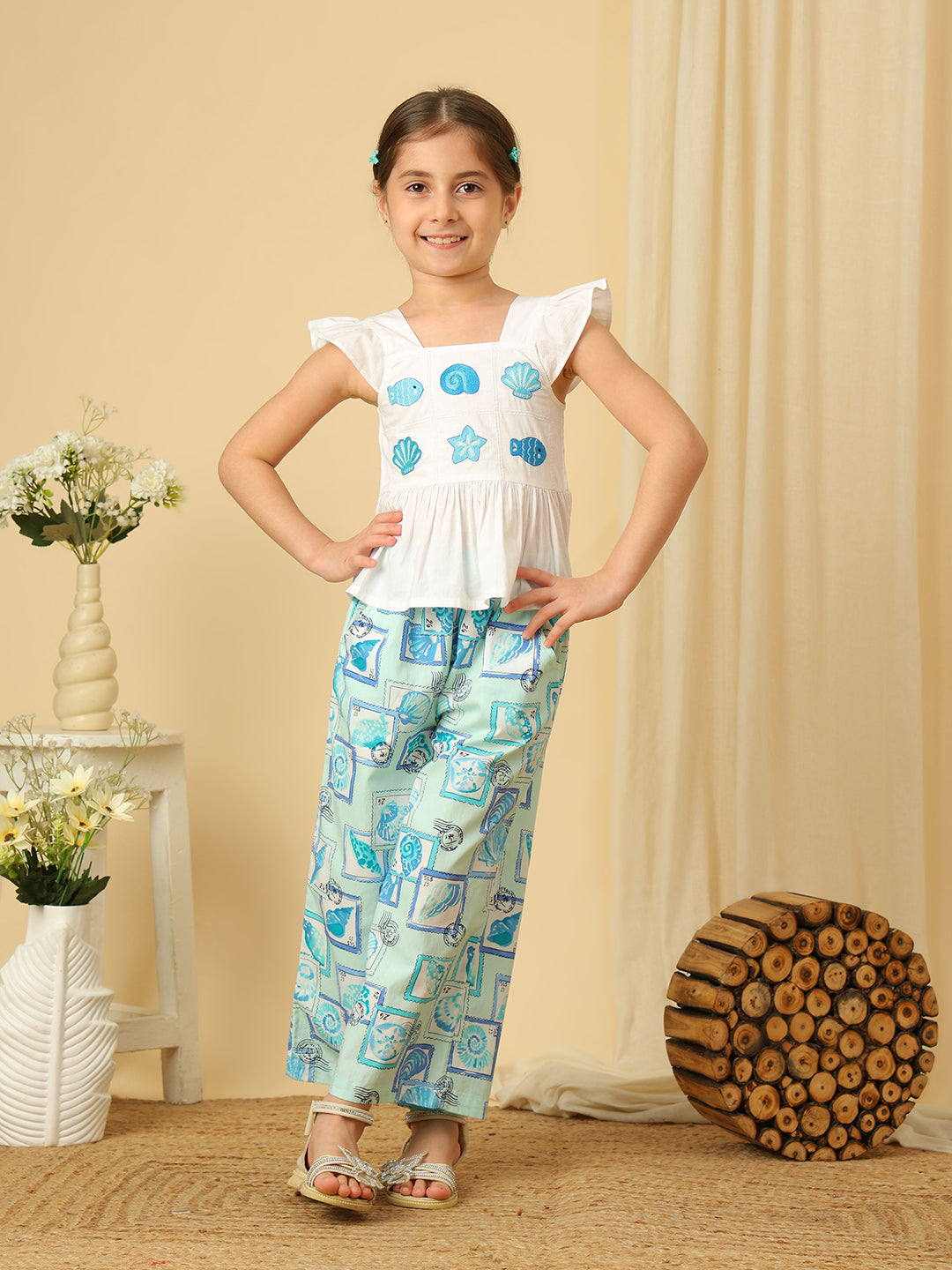 Girls white peplum top with blue seashell and fish embroidery, paired with marine print wide-leg pants co-ord set