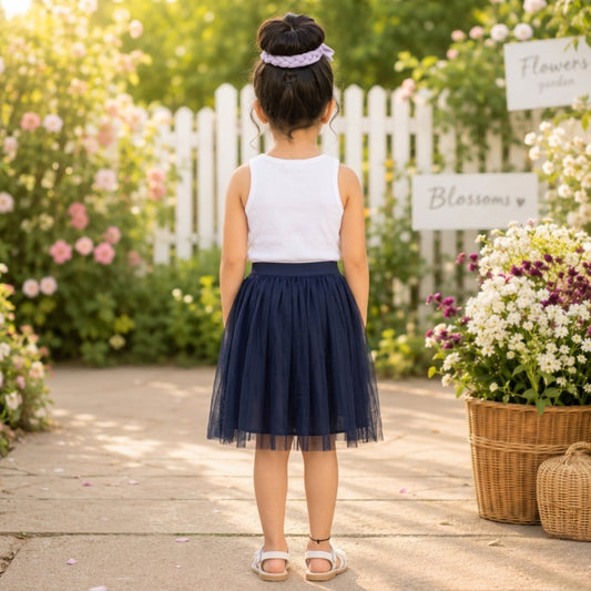 White top with navy blue girls layered tulle skirt and flared hem