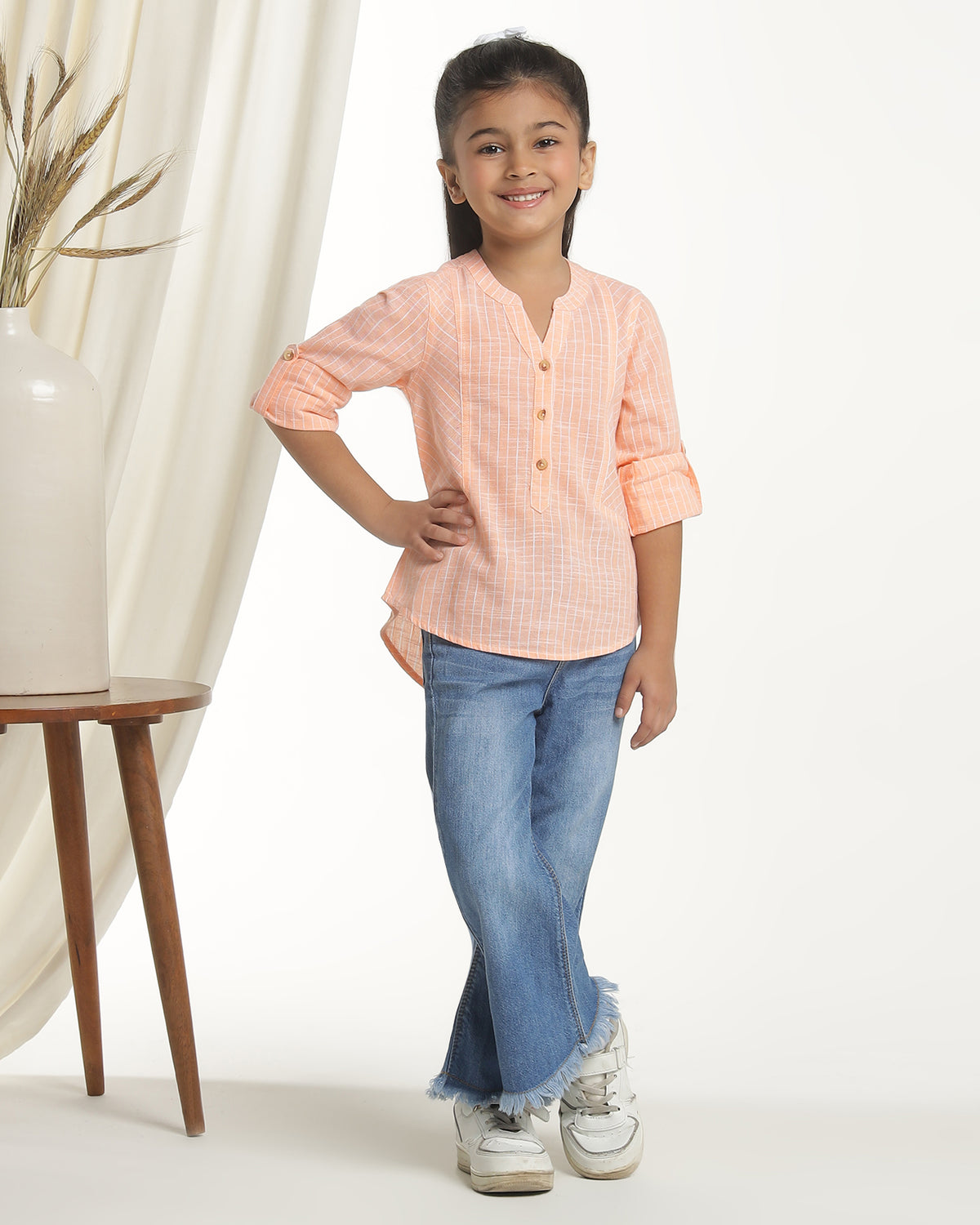Peach girls long sleeve top with ruffle detailing and round neckline