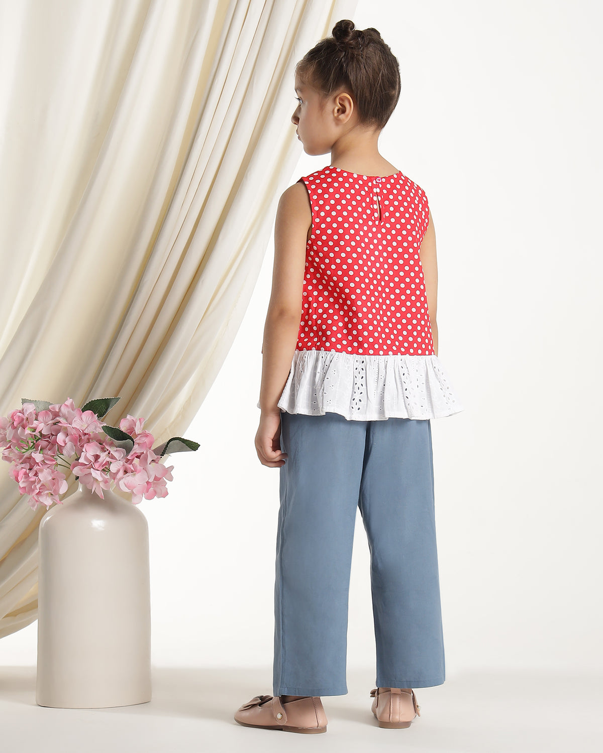 Red and white polka dot girls sleeveless dress with striped ruffle hem and floral applique