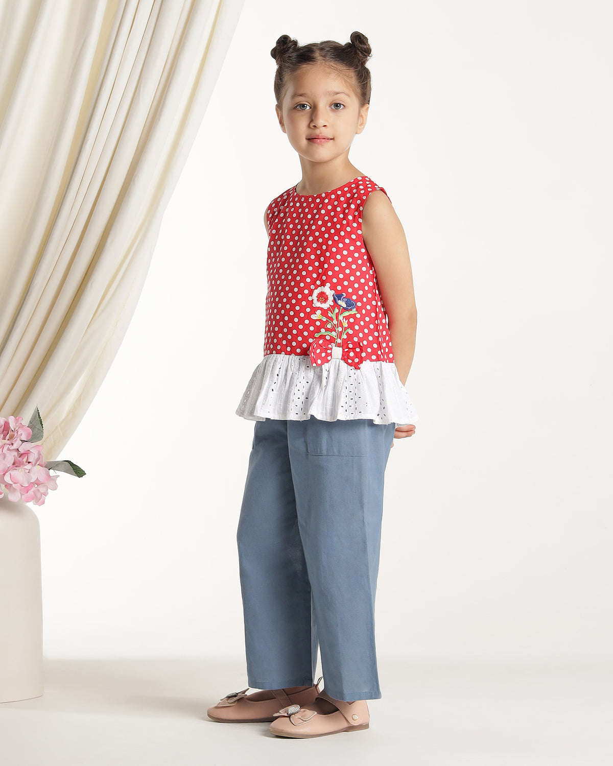 Red and white polka dot girls sleeveless dress with striped ruffle hem and floral applique