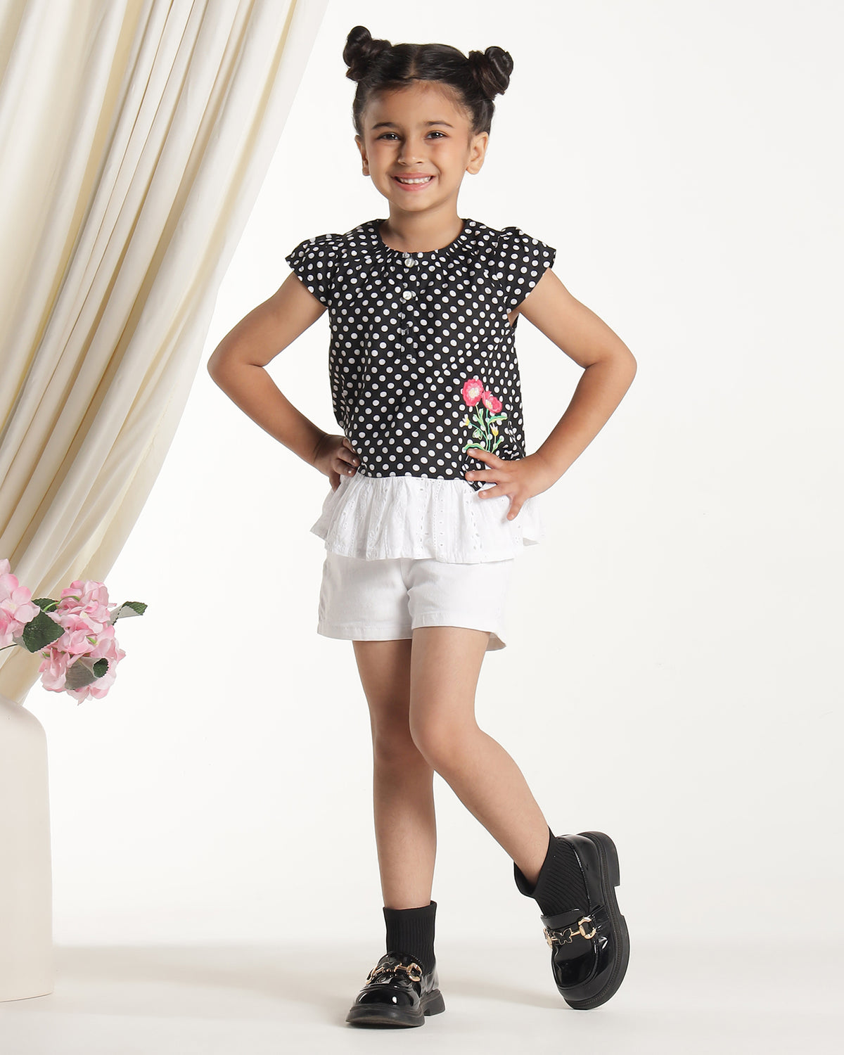 Black and white polka dot girls short sleeve dress with floral applique and ruffle hem