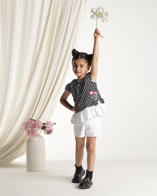 Black and white polka dot girls short sleeve dress with floral applique and ruffle hem