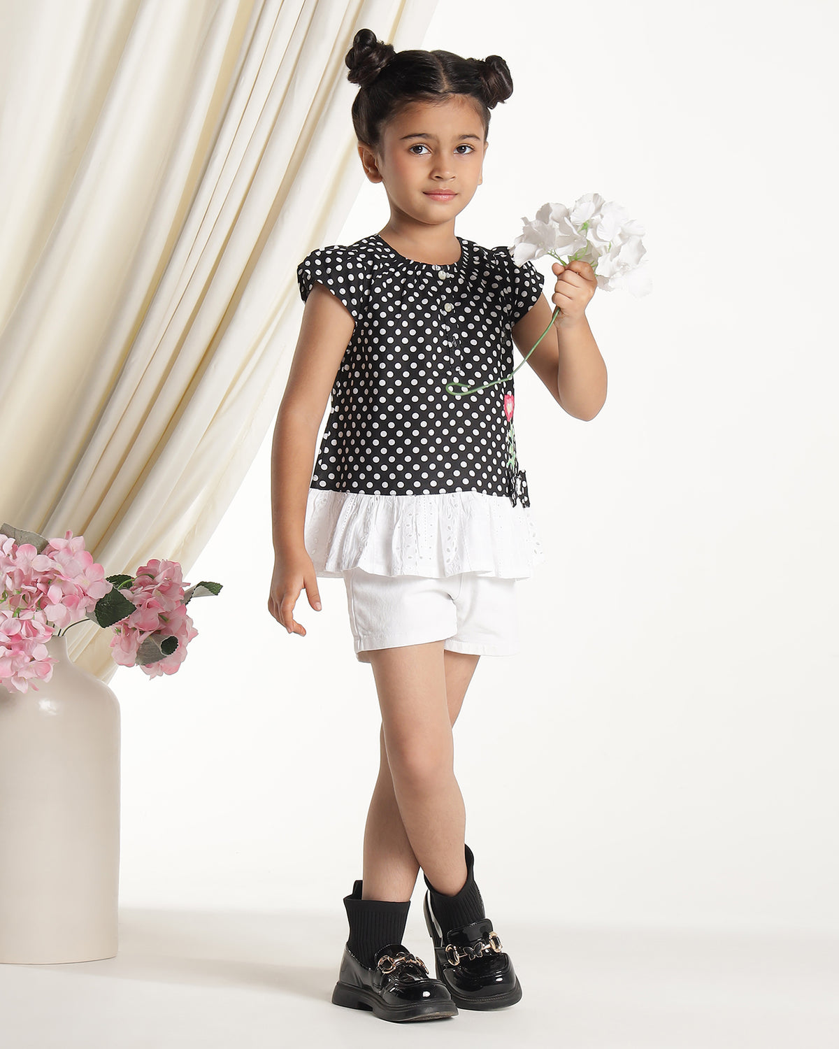 Black and white polka dot girls short sleeve dress with floral applique and ruffle hem