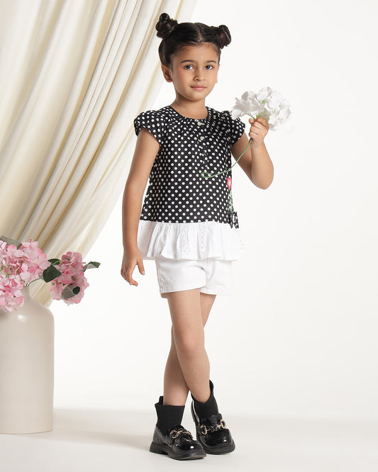 Black and white polka dot girls short sleeve dress with floral applique and ruffle hem