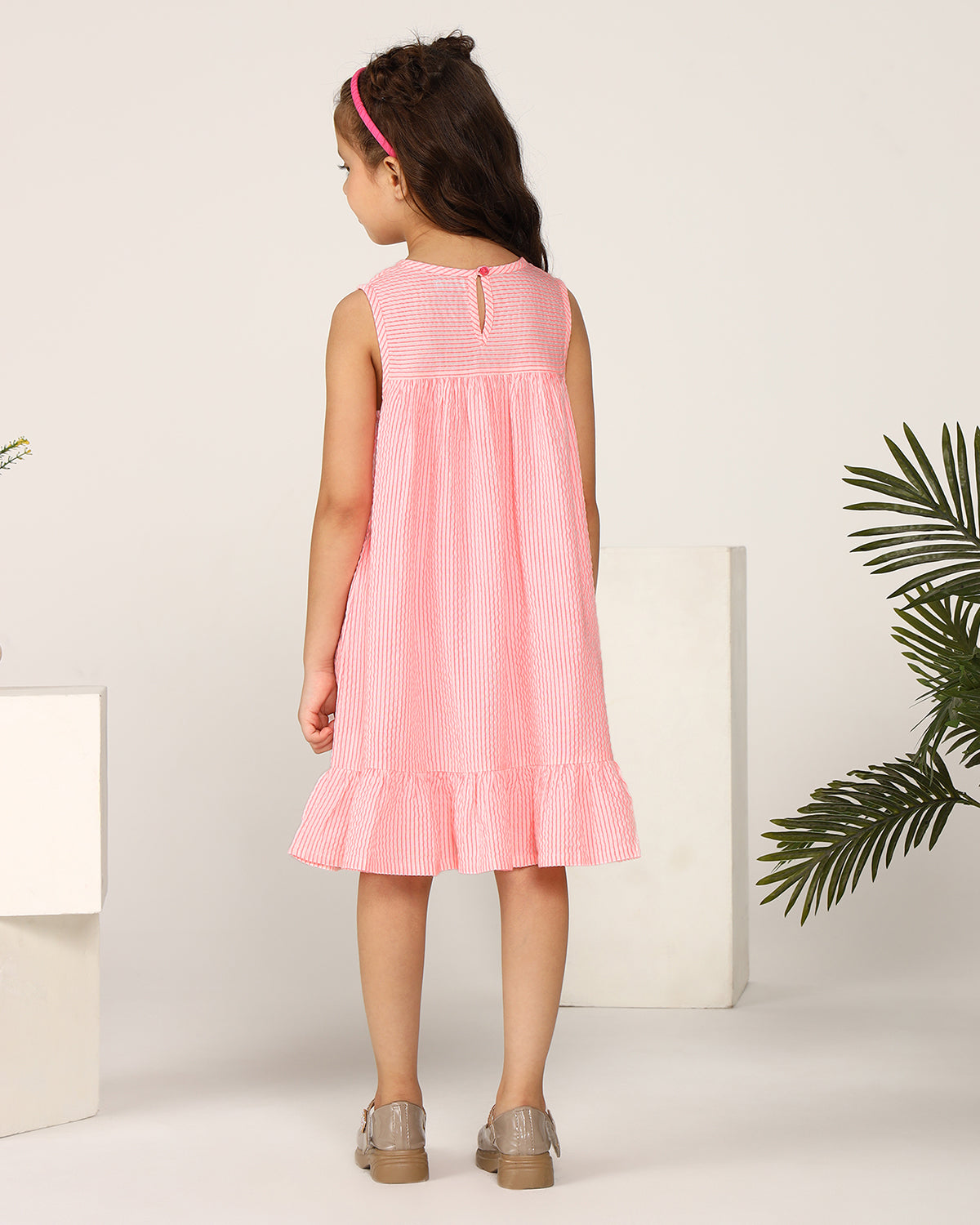 Pink girls sleeveless A-line dress with ruffle detailing and flared hem