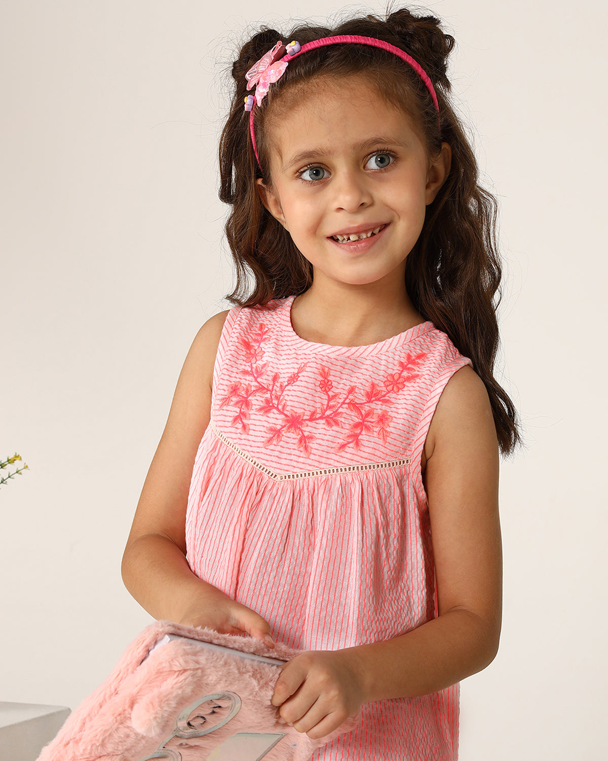 Pink girls sleeveless A-line dress with ruffle detailing and flared hem