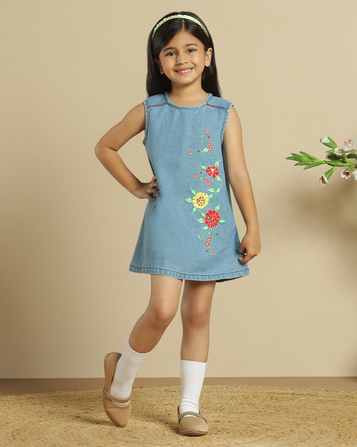 Blue denim girls sleeveless dress with colourful floral embroidery and front pocket detailing
