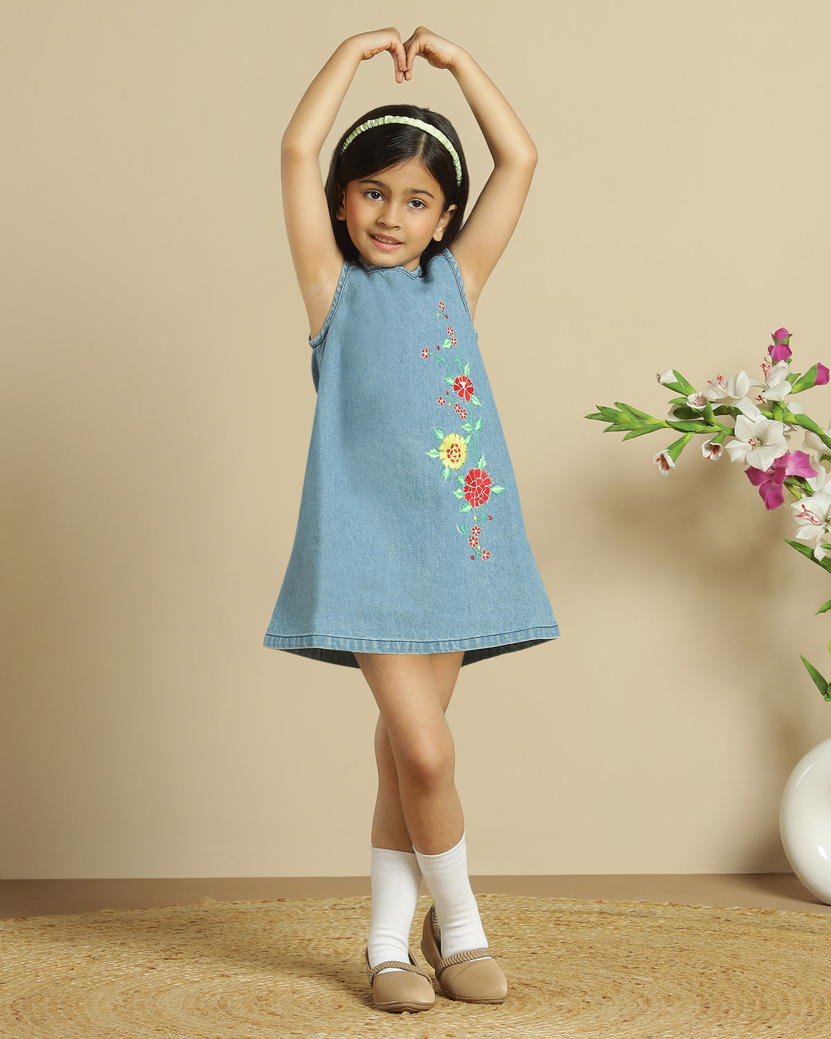 Blue denim girls sleeveless dress with colourful floral embroidery and front pocket detailing