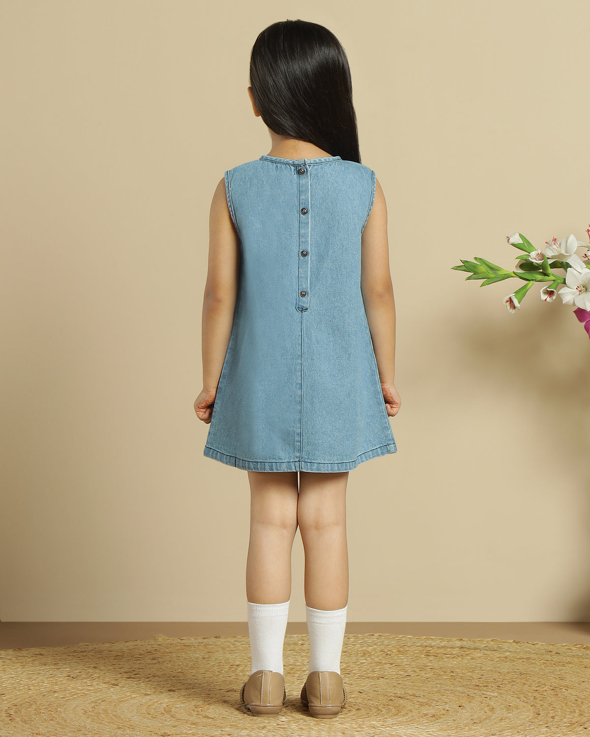 Blue denim girls sleeveless dress with colourful floral embroidery and front pocket detailing