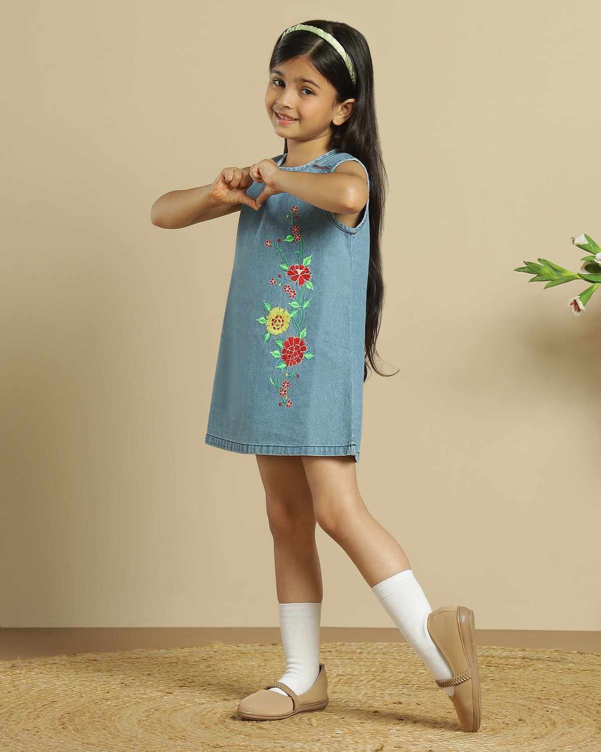 Blue denim girls sleeveless dress with colourful floral embroidery and front pocket detailing