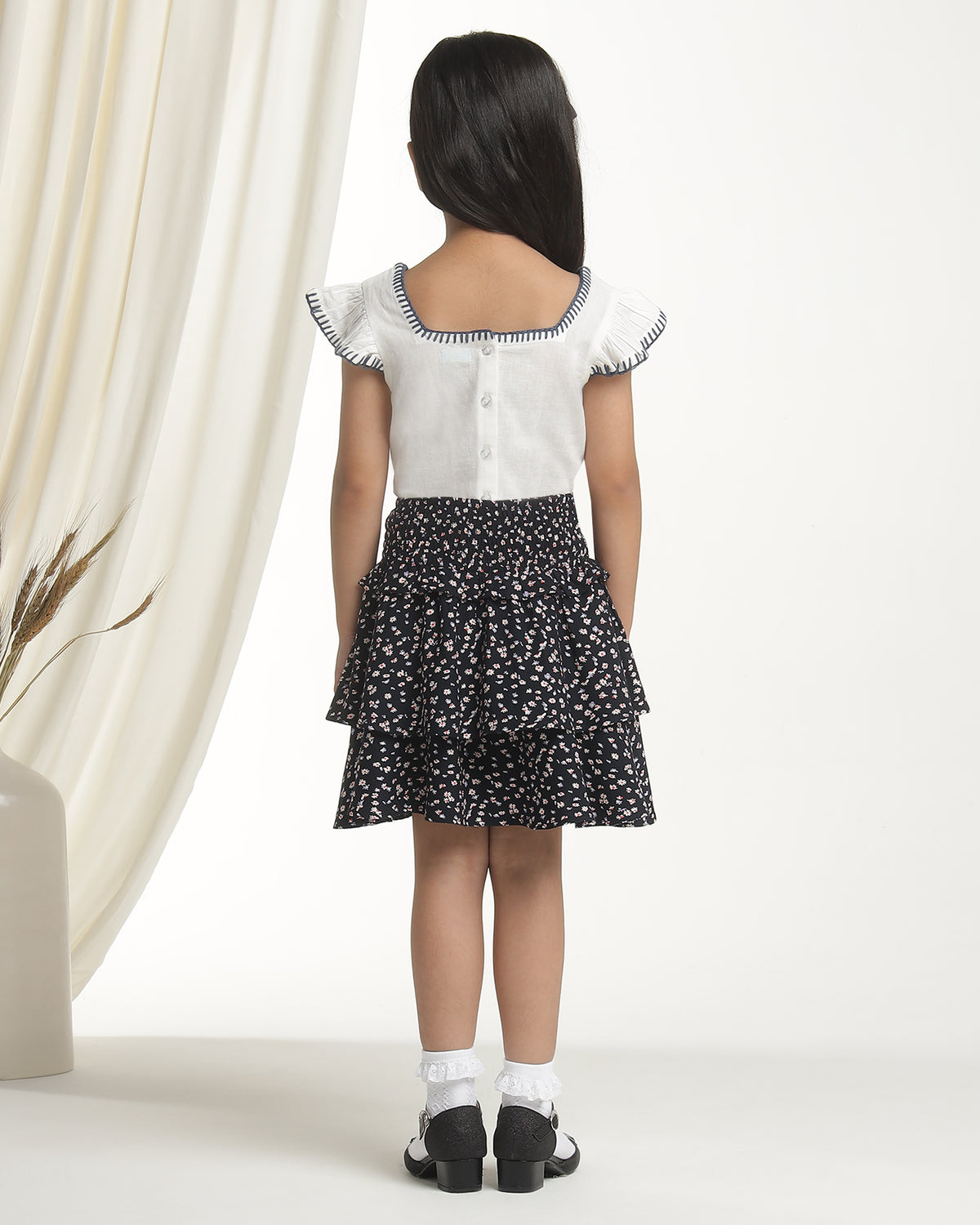 Black floral printed girls flared skirt with layered ruffle detailing and elasticated waist
